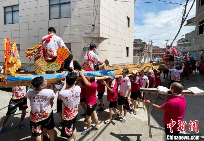 圖為5月29日，長(zhǎng)樂(lè)江田鎮(zhèn)村民們肩扛著新龍舟舉行入水前游街儀式?！埍?攝