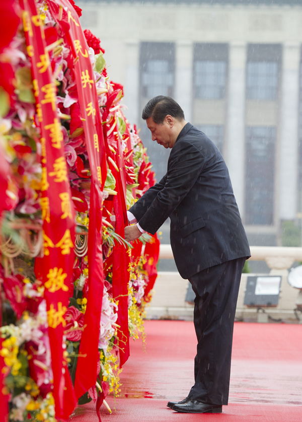 2013年10月1日上午，在首都各界代表向人民英雄紀(jì)念碑敬獻(xiàn)花籃儀式上，習(xí)近平整理花籃上的緞帶。